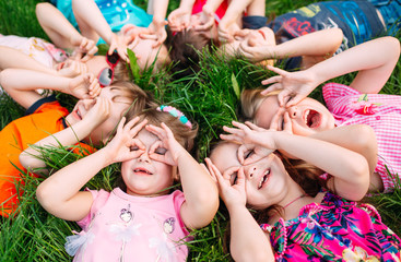 A group of children lying on the green grass in the Park. The interaction of the children.