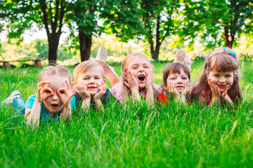 A group of children lying on the green grass in the Park. The interaction of the children.