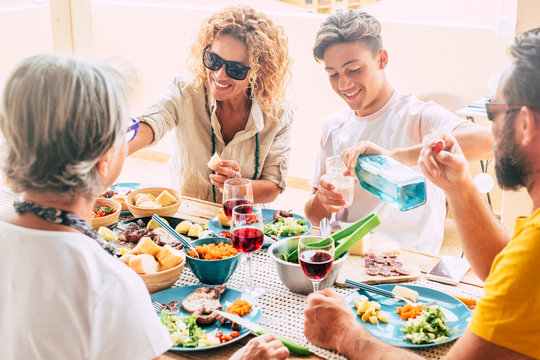 People Enjoying Bbq Outdoor On The Terrace. Happy Family Drinking And Eating. Wooden Table. Bright Background