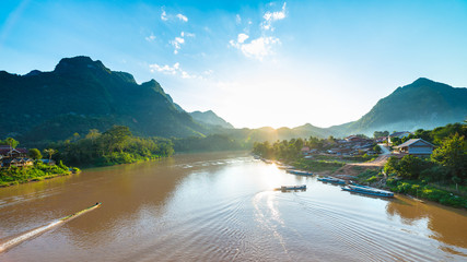 Boats on Nam Ou River at Nong Khiaw villlage Laos sunset clear sky dramatic landscape famous travel destination backpacker in South East Asia - obrazy, fototapety, plakaty