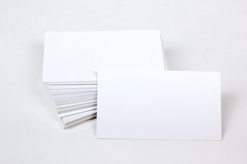 Mockup of business cards fan stack at white textured paper background.