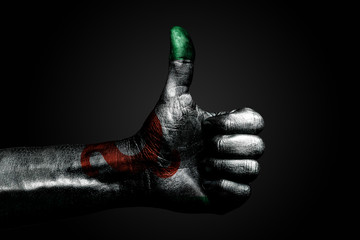 A hand with a drawn Ingushetia flag shows a finger up sign, a symbol of success, readiness, a task done on a dark background.