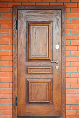 Wooden oak door in a brick wall