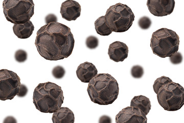 Falling black pepper, peppercorn, isolated on white background, selective focus