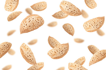 Falling Almond nut in shell isolated on white background, selective focus