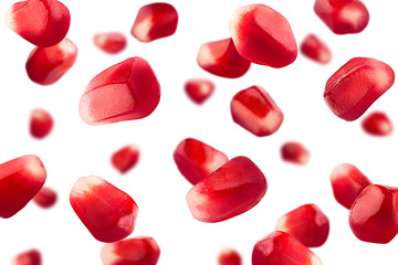 Falling pomegranate seeds isolated on white background, selective focus
