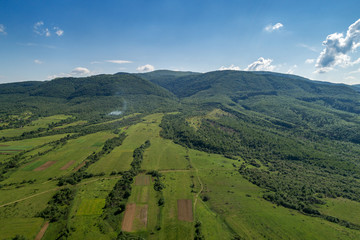 Mountains covered with green forest and river. Carpathians. View from above. Picture taken with a drone.