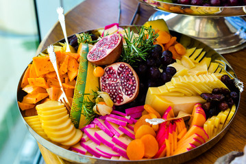 tray with fruits and cheeses on buffet table, healthy food, antipasto,  hors d'oeuvre, cold dish,...