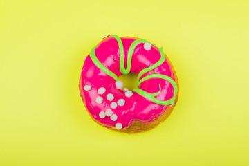 Donut with red glaze on a yellow background