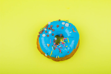 Donut with blue glaze on a yellow background
