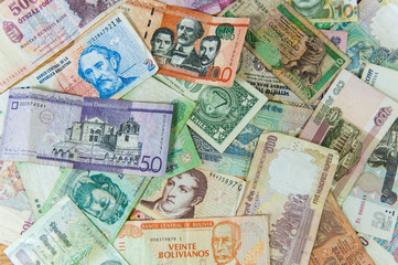 Many international banknotes spread on table