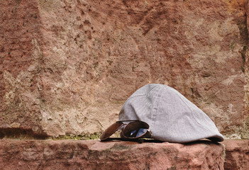 Cap and sunglasses on the old wall