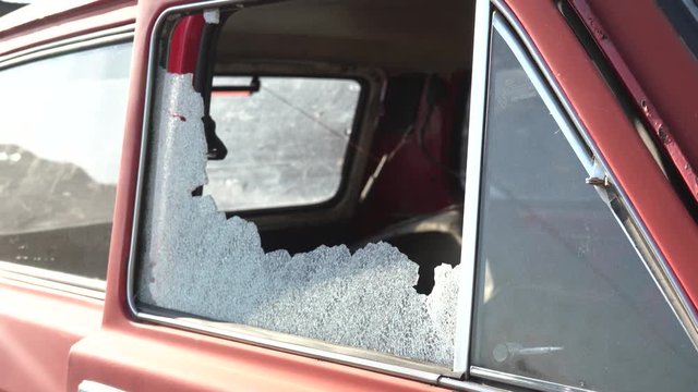 The car after the accident. Car window smashed by a thief. Car broken window. Broken right side window of a car parked on the street. 