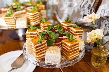 Pieces of Napoleon cake on a white plate on a wooden one . Russian cuisine, layer cake with cream....