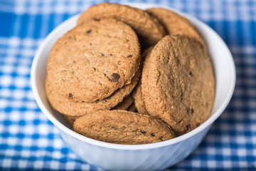 Delicious cookies in a white bowl, on a kitchen cloth