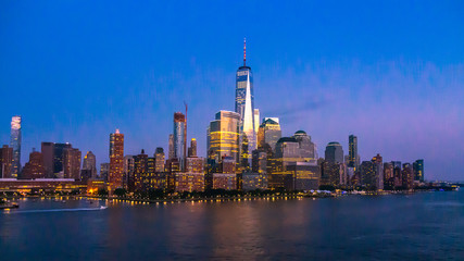 Fototapeta na wymiar New York City Skyline with Skyscrapers Illuminated at Dusk