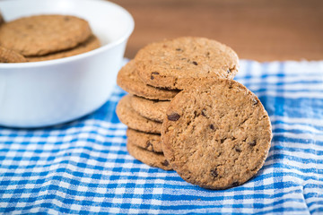 Delicious cookies stacked on a cloth, on a wooden table