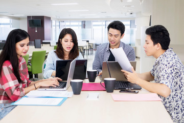 Busy business team works with laptops in office