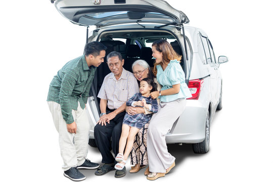 Little Girl Sits With Her Big Family In Car Trunk