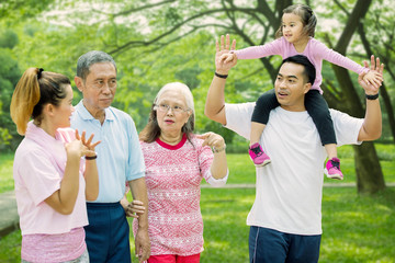 Multi generation family walks together in the park
