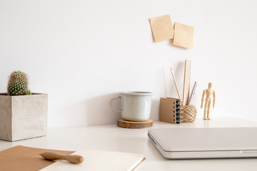 Workspace with laptop, wooden supplies and wooden pad under coffee mug at home office desk....