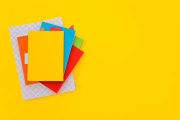 Stack of notebooks on colorful background. Top view.