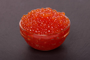 red caviar in glass bowl on black background