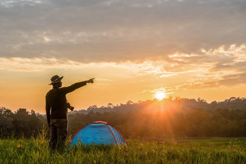Fototapeta na wymiar traveller having camping with tent on grass field in morning of sunrise