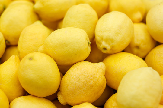 Pile of ripe yellow lemons in summer market for sale