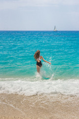 Brunette girl enjoying her vacation time. Running towards the sea.