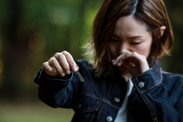 泣きながら鍵を渡す女性