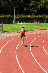 Fototapeta premium Teen Hispanic Woman Running On Track Shorts And Top