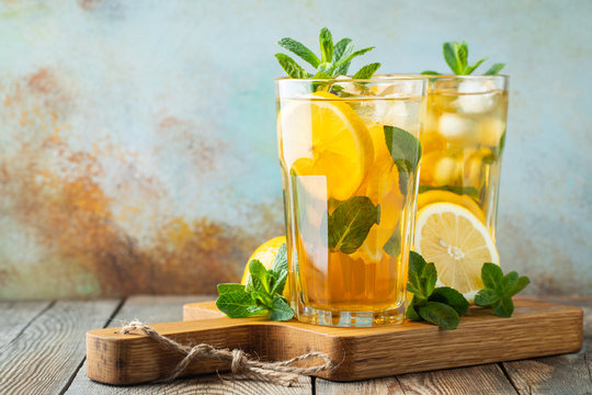 Traditional Iced Tea With Lemon And Ice In Tall Glasses On A Wooden Rustic Table. With Copy Space