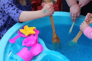 Blue Bath Jelly in a Water Table Activity. Fun summer time activity. Children enjoying this experimental play/STEM activity.
