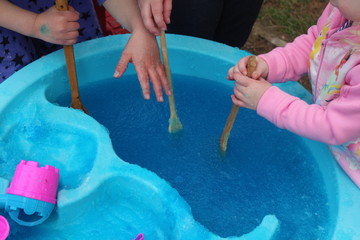 Blue Bath Jelly in a Water Table Activity. Fun summer time activity. Children enjoying this experimental play/STEM activity.