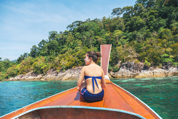 Asian women relaxing in summer holiday tropical sea with long-tail boat in thailand.
