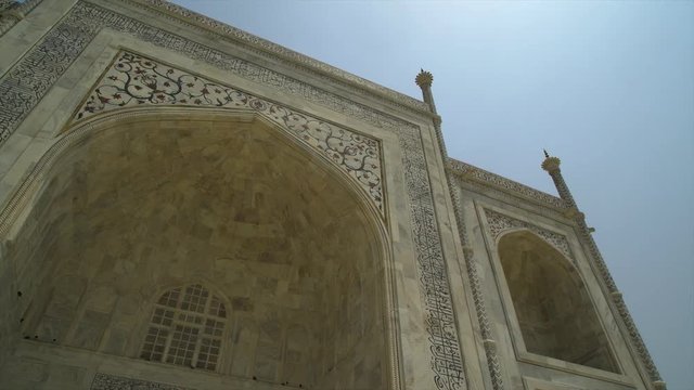 A hand held, panning, high angle, medium shot of the mosaic front of the entrance to the temple.