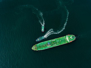 Aerial top view Tugboad drag Oil ship tanker on the sea going to refinery for load/unlod oil for transportation.