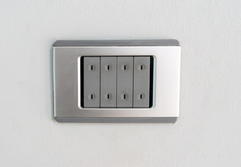 An electric light switch against white wall