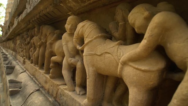 A hand held, extreme close up shot of stone sculptures embodying men and horses.