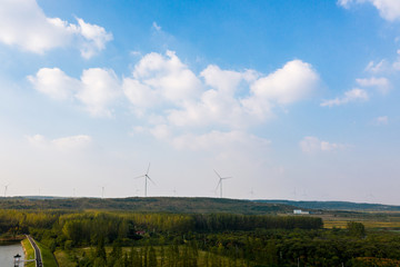 Fototapeta premium The windmills on the top of a mountain. They generate green energy from the nature.