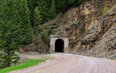 Black tunnel entrance into side of rock mountain