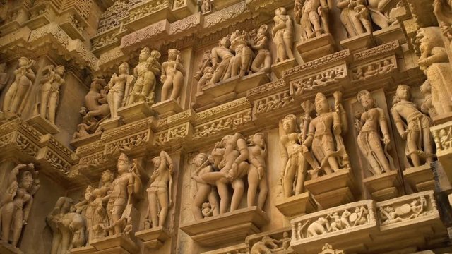 A hand held, high angle, medium shot of many graceful statues of people.