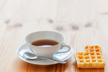 Teacup and biscuit on the table