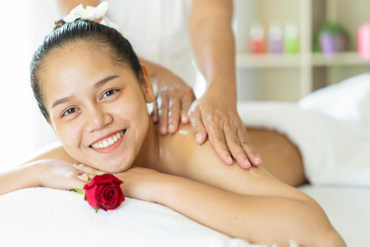 Beautiful young Asian woman having a oil wellness back massage and feeling visibly good about it in spa salon environment. spa beauty treatment, skin care concept.