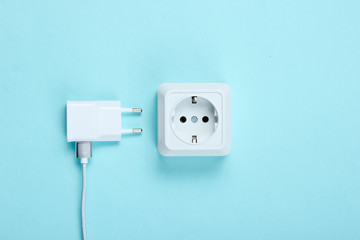 Charger and power outlet on blue background