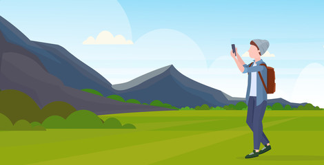 man taking selfie photo on smartphone camera casual male cartoon character in hat with backpack mountains landscape background flat full length horizontal vector illustration