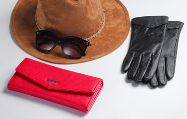 Naklejka premium Women's fashion accessories. Red leather wallet, sunglasses, gloves close-up on white background