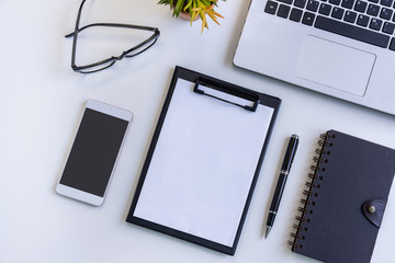 Empty screen Smart phone and tablet with laptop on business desk office with copy space, Top view