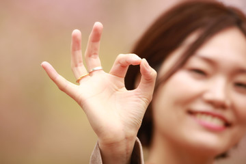 手で丸をつくる女性
